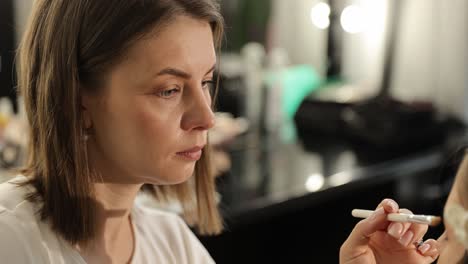 skilled makeup artist expertly applies makeup on a model in a professional studio setting