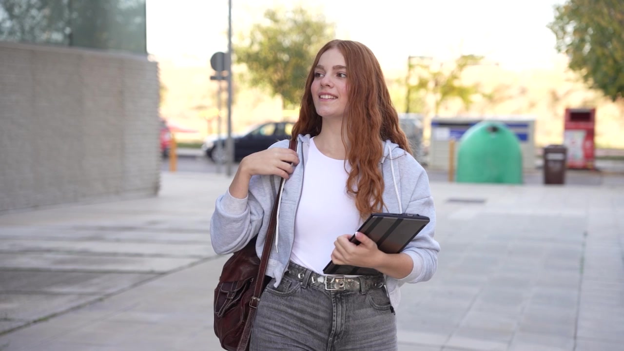 Una giovane donna che interagisce con gioia con la tecnologia mentre si gode l'aria aperta in città.