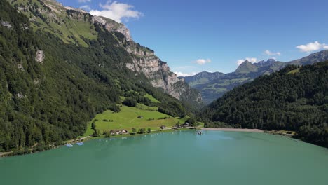 Vista-Panorámica-Y-Cautivadora-De-Un-Hermoso-Lago-Alpino-Rodeado-De-Magníficas-Montañas-Verdes,-Destino-Para-Recreación-Pacífica-Y-Actividades-De-Ocio.-Barcos-Estacionados-En-El-Borde-Del-Lago.