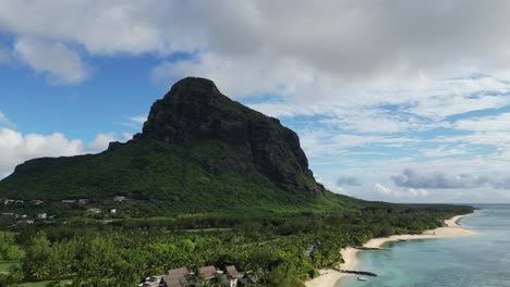 Le-Morne-Brabant-mountain-rising-above-the-beach-on-Mauritius-island,-establishing-shot