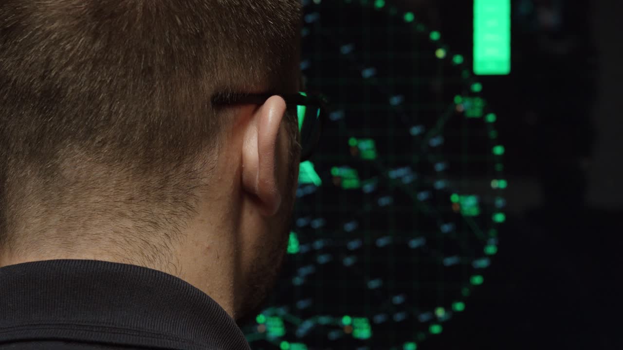 Rear view of a man monitoring a radar display with aircraft tracking data, illustrating airspace surveillance, aviation control systems and security monitoring technology