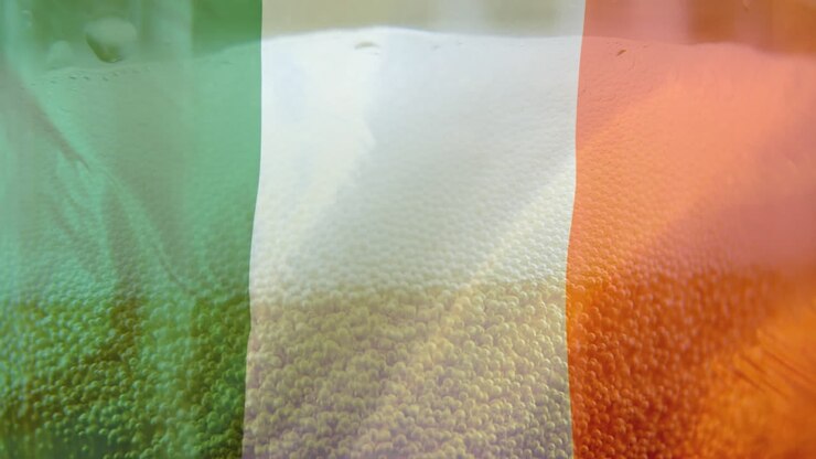 Birra alla spina e una bandiera irlandese in primo piano