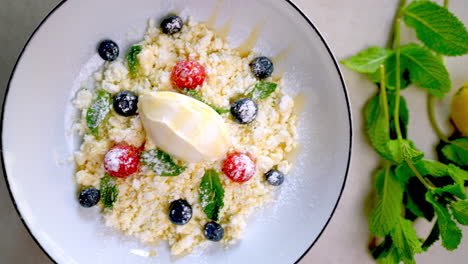 creamy white plated dessert displaying velvety surface, topped with vibrant blueberries, raspberries, mint garnish, glistening honey drizzle highlighting rich texture and sweet flavor profile