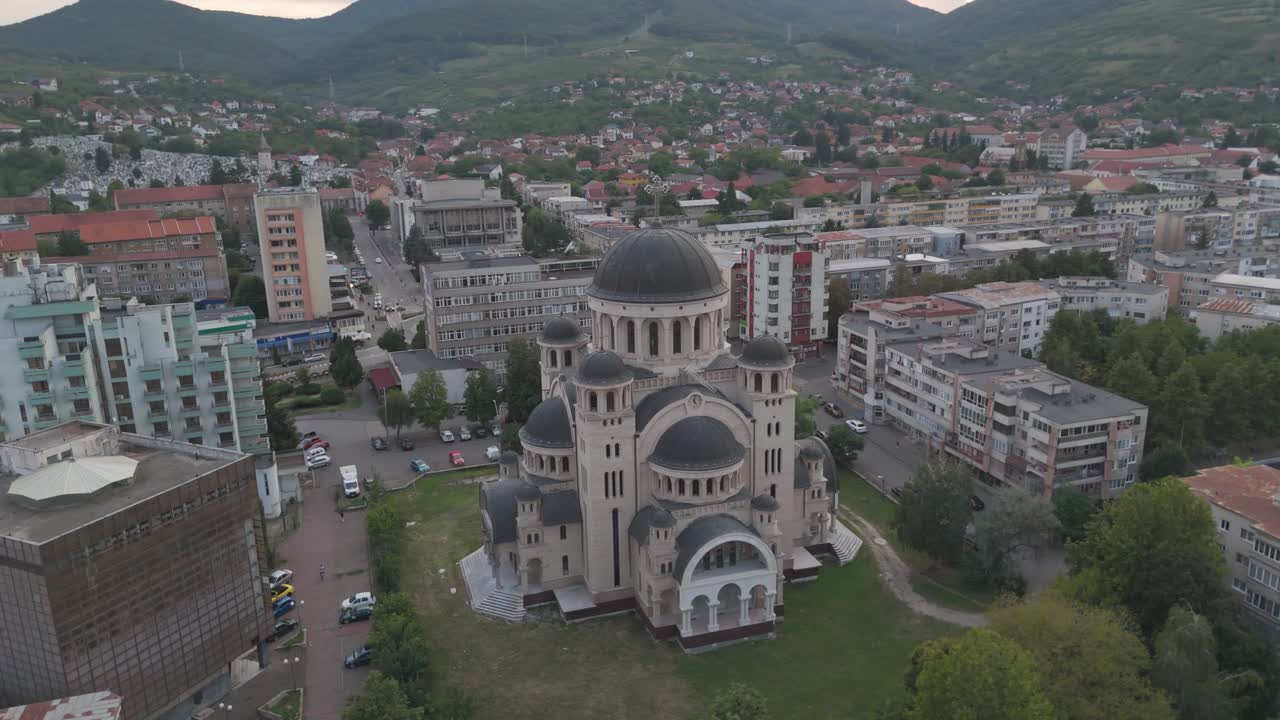 Scenic aerial flyaround capturing Deva’s cathedral and nearby urban environment