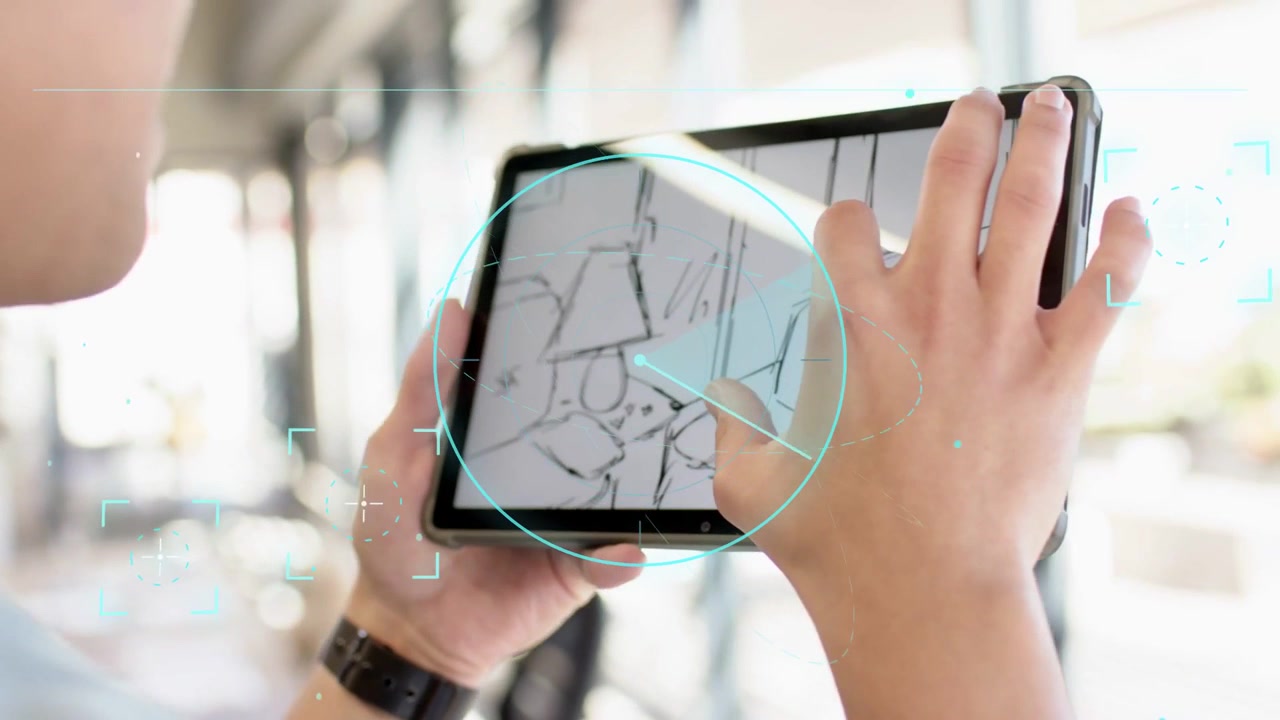 Designer che tiene un tablet in ufficio, tocca uno schizzo e pizzica per modificare il layout con tracciamento HUD.
