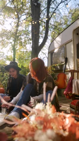 two friends enjoying an autumn afternoon by a campervan