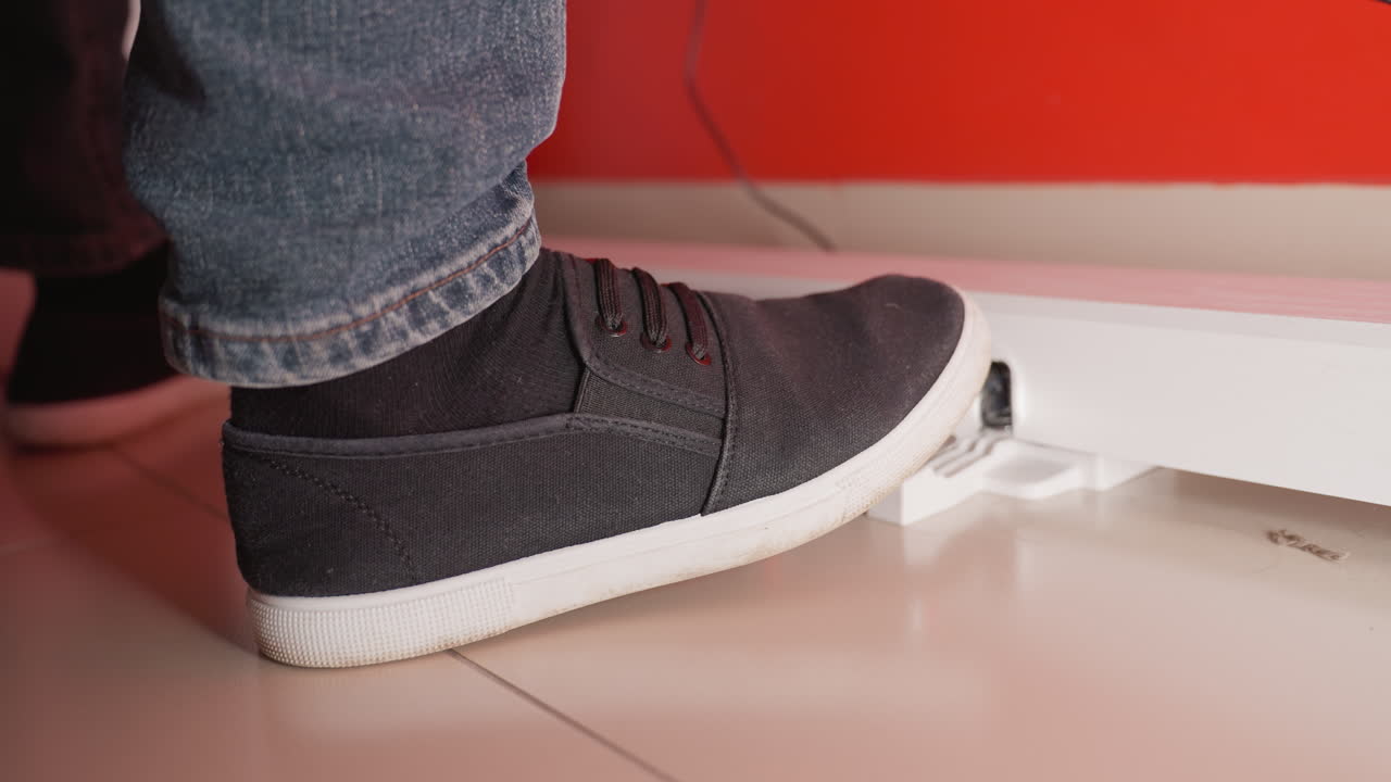 검은 신발과 파란 청바지를 입고 피아노 페달을 는 발의 클로즈업, 피아노 연주의 행동을 강조합니다.