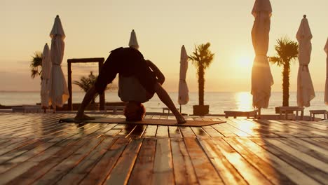 review of a guy who meditates in a special position from yoga exercises in the morning on a sunny beach