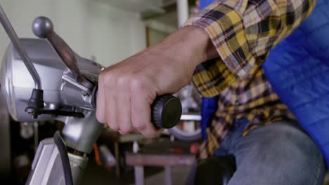 mecánico masculino reparando scooter en el garaje de reparación 4k