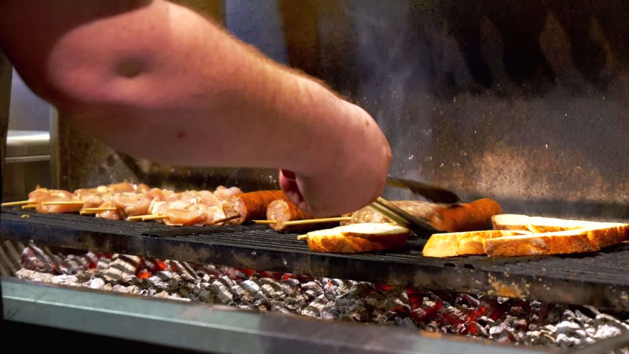 셰프는 소시지, 스피어드 고기, 크루톤을 그릴 랙에 놓습니다.
