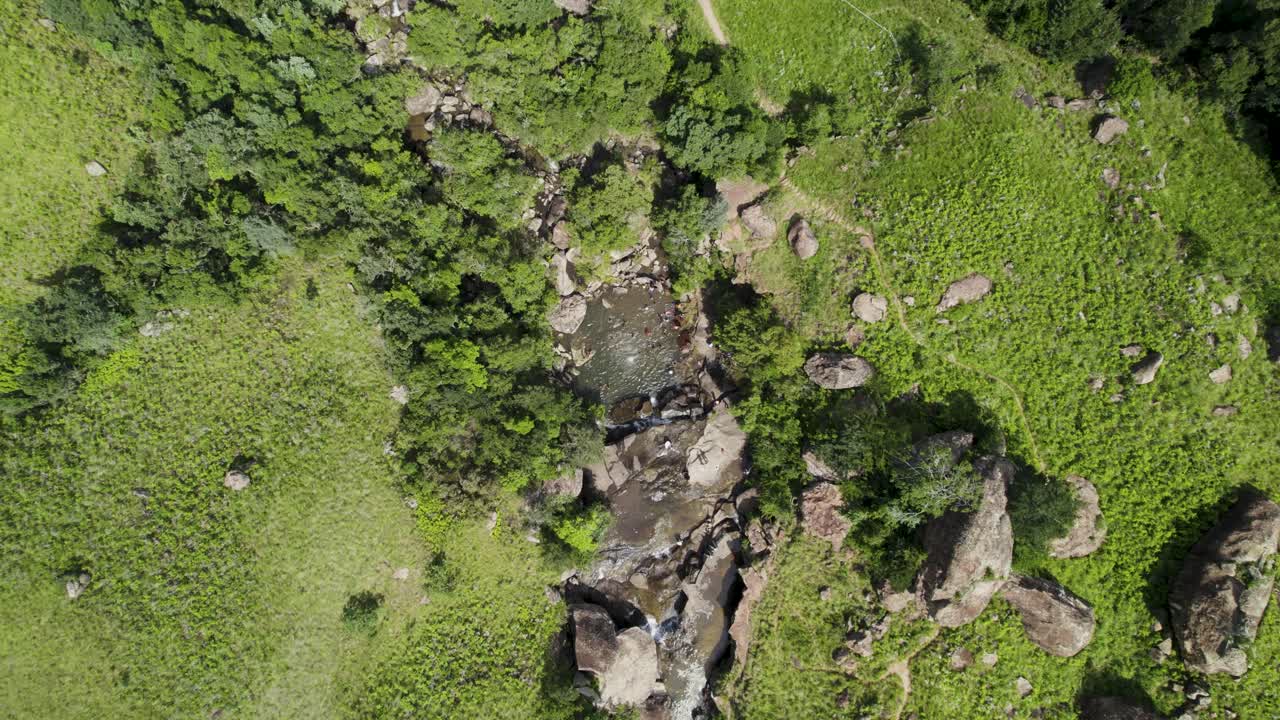 Drone Footage: People Enjoying a Natural River Pool in a Lush Landscape