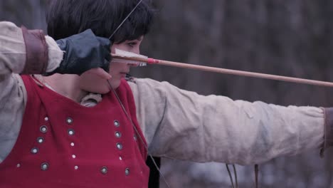 warrior woman shoots a bow in the target