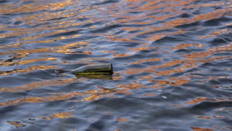 a message in a bottle floats in a sun reflected river