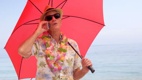 Retired-man-on-the-phone-under-his-umbrella