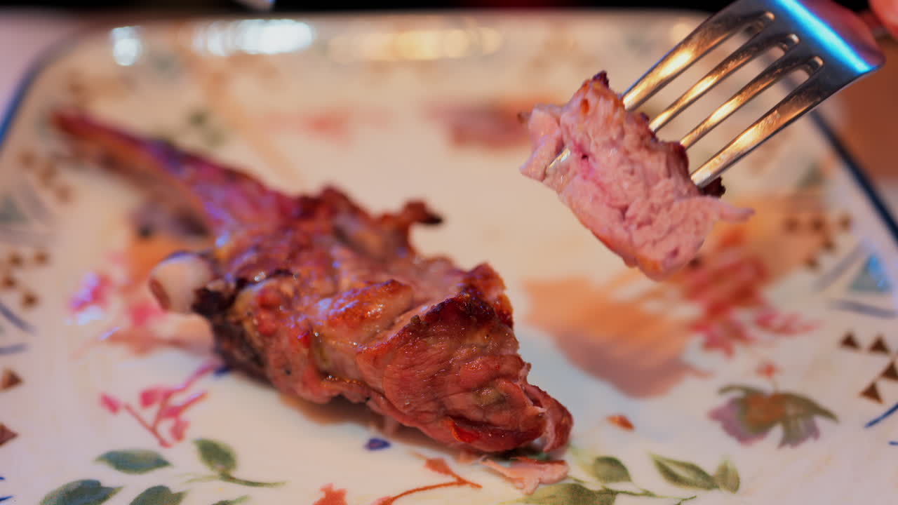 Close up of lamb chops being cut on a plate at a restaurant