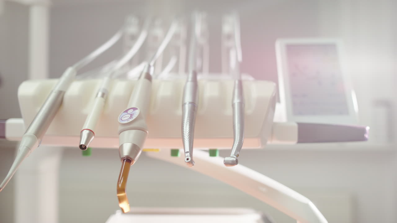 Dentist moves behind set of tools used during oral exam and treatment, close-up