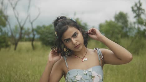 Beautiful-Indian,-Asian-Girl-fixing-her-hair-while-looking-at-the-camera