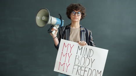 woman holding protest sign with megaphone: my mind, my body, my freedom