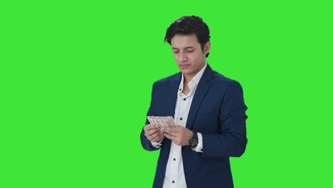 Sad-Indian-manager-counting-money-in-office-Green-screen