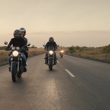 a group of bikers ride on motorcycles on the highway