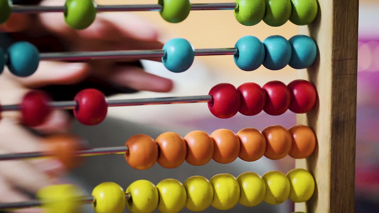 niño jugando con un ábaco colorido en cámara lenta