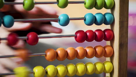 young boy playing with a colourful abacus in slow motion