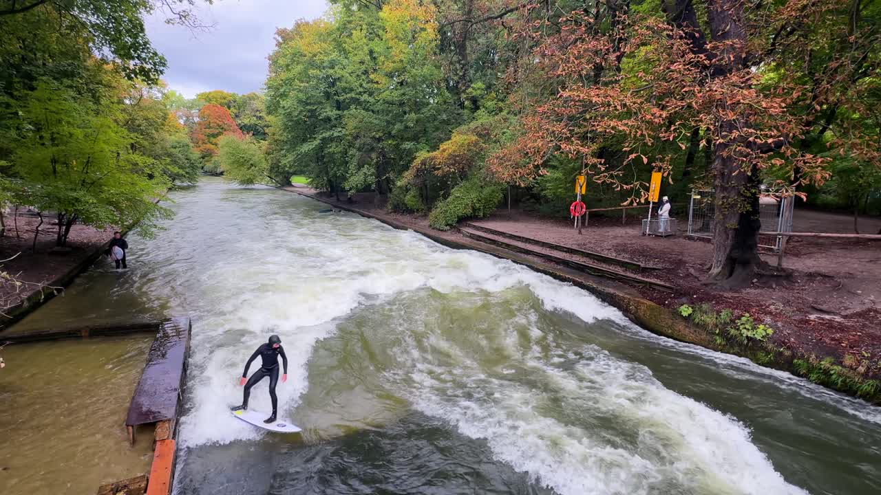 Efterår våddragt surfere Flodsurfing morgen Eisbachwelle Eisbach Isar flod München Tyskland broudsigt Englischer Garten kunstig menneskeskabt stående bølge actionsportsgrene vandsport stunts pan
