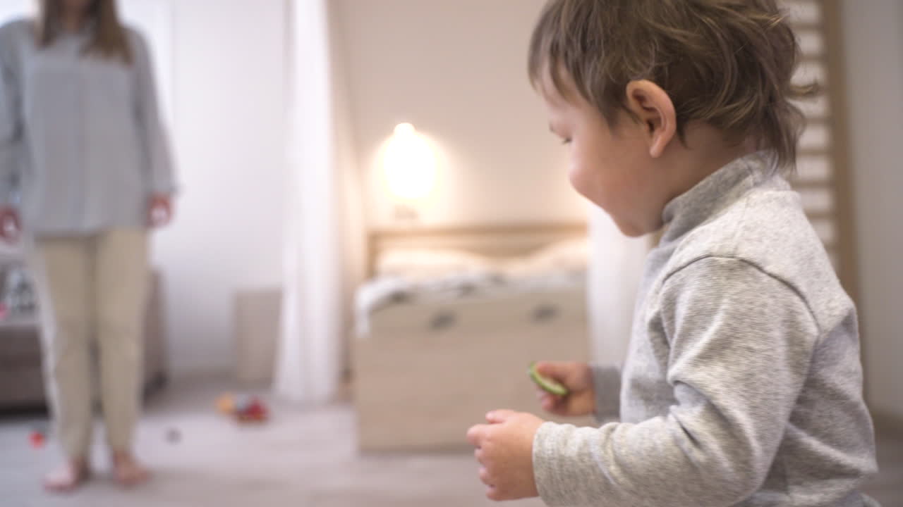 Close Up View Of A Baby Holding A Slice Of Cucumber