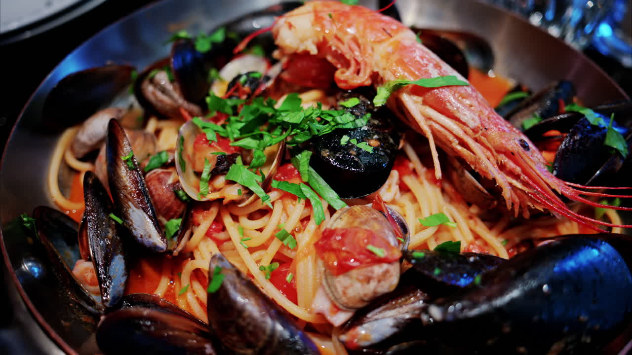 Close up of pasta with tomato sauce and mussels in a pan