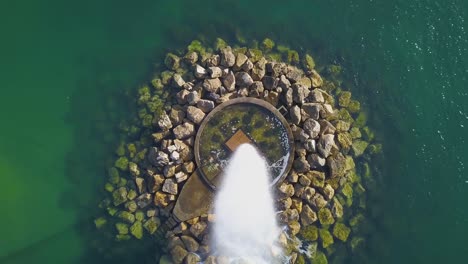 aerial view around a ocean fountain, on the coast of lisbon, portugal - down and orbit movement, drone shot