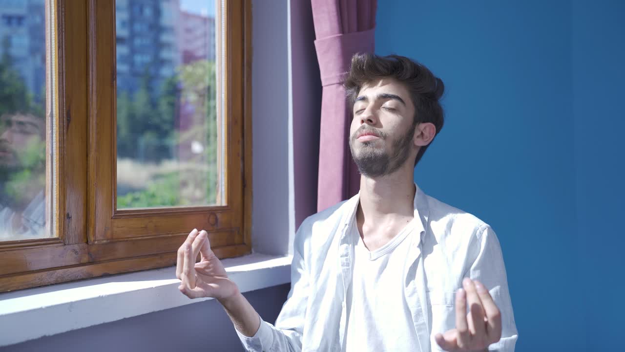 hombre haciendo yoga afuera frente a la ventana.