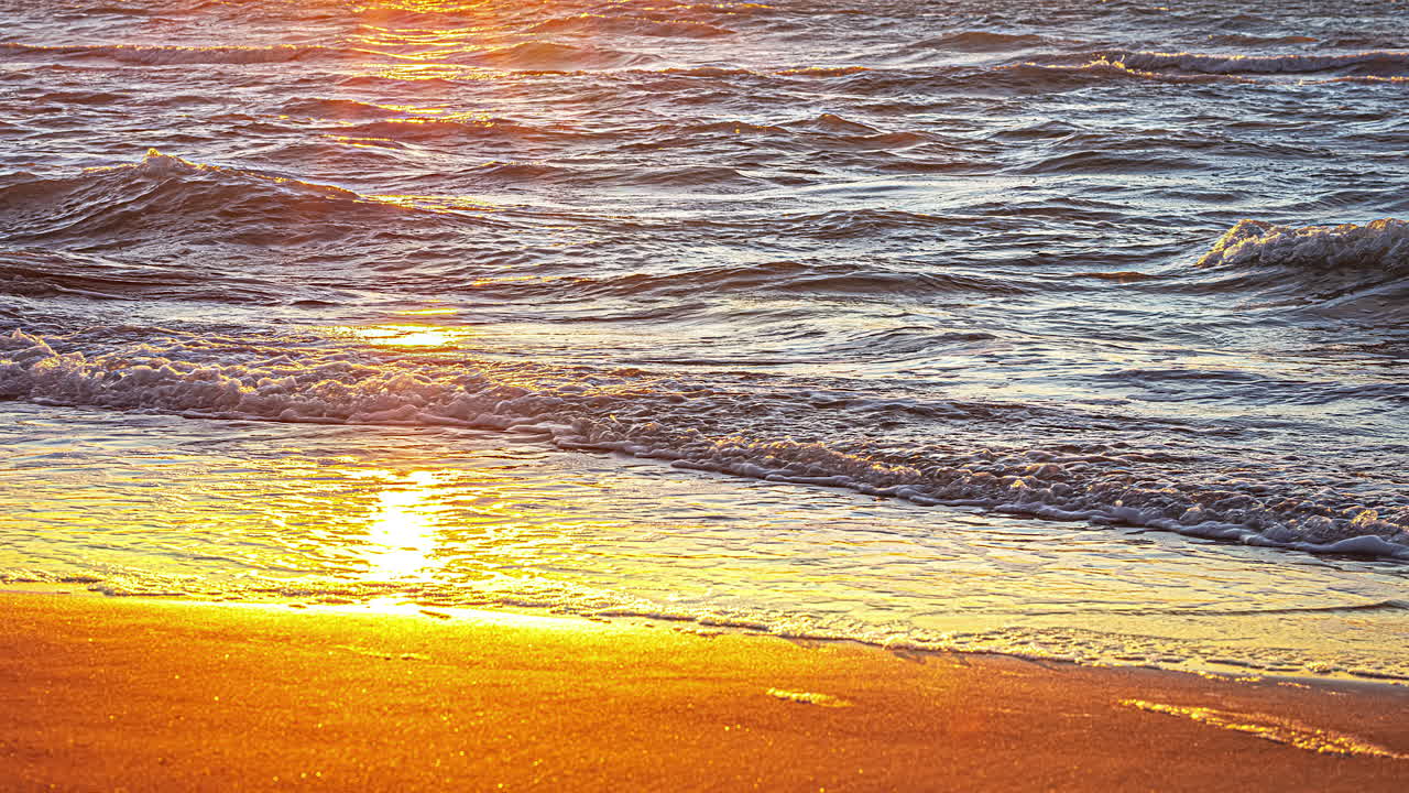 해가 질 때 모래사장에 부서지는 파도의 시간 경과