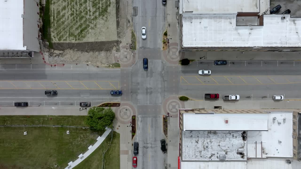 Intersection in downtown Marshalltown, Iowa with traffic moving and drone video overhead moving down