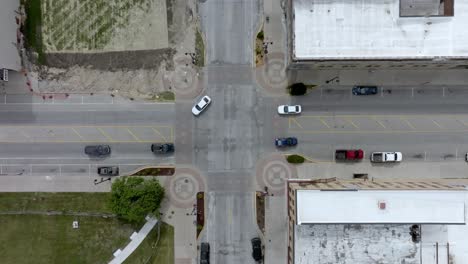 intersección en el centro de marshalltown, iowa con el tráfico en movimiento y el video de drones sobre la cabeza en movimiento hacia abajo