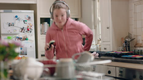 happy teenage girl dancing in kitchen having fun celebrating weekend performing funny dance moves listening to music wearing headphones