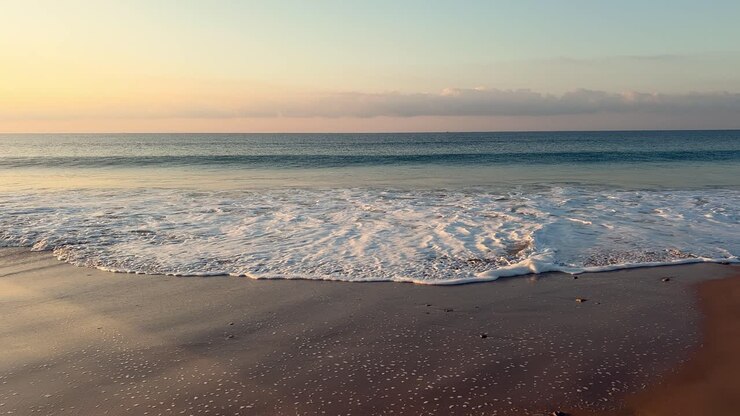 waves lapping on the shore at sunset, slowmo, day