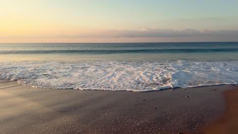 waves-lapping-on-the-shore-at-sunset,-slowmo,-day