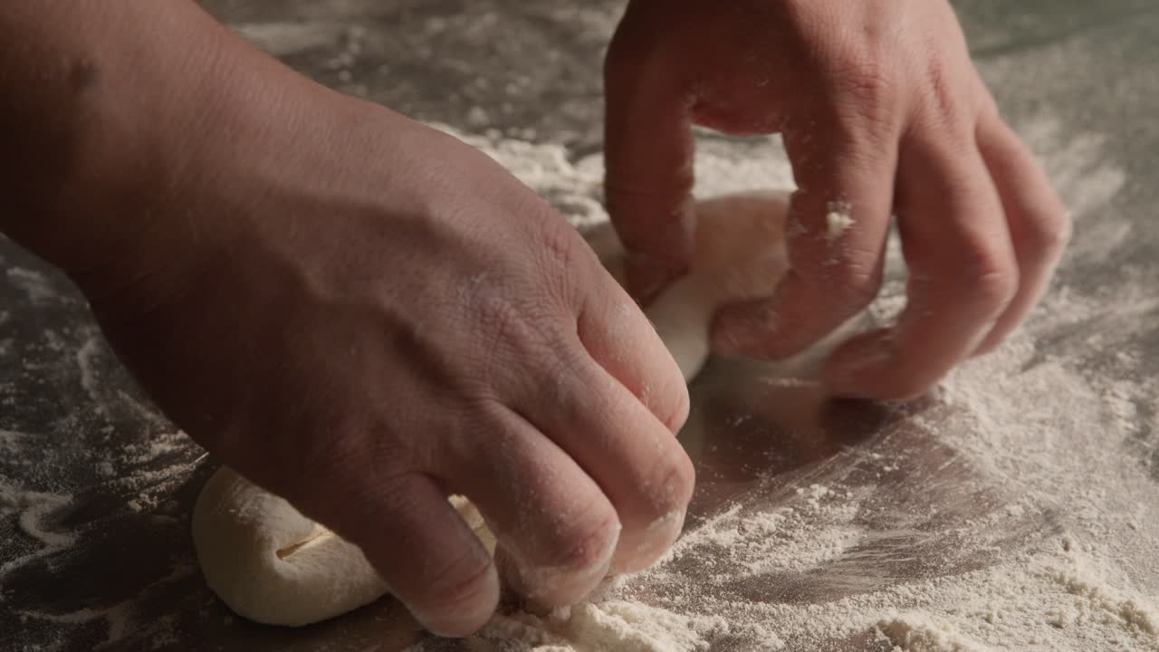 Preparing dough in closeup on chef hands, kneading and stretching dough for khachapuri