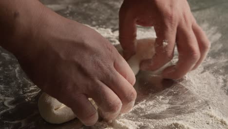 preparing dough in closeup on chef hands, kneading and stretching dough for khachapuri