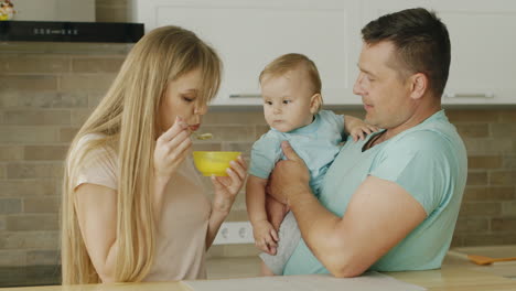 Young-Parents-Play-With-Their-Little-Son-While-They-Try-To-Feed-Him-From-A-Spoon-1