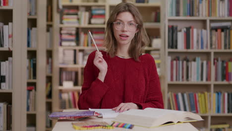 mujer joven en la biblioteca recuerda mientras estudia