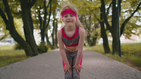 tired athletic fitness sport runner child girl taking break after jogging training, finishing race