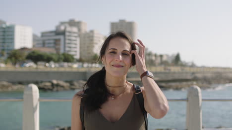 Retrato-De-Una-Hermosa-Mujer-Elegante-Sonriendo-Confiada-Tocando-El-Cabello-En-La-Soleada-Playa