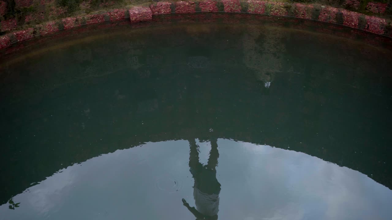 우물 벽 위를 걷는 하늘과 사람의 반사