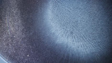 blue alcohol ink bloom in macro view, forming abstract textures with soft lighting