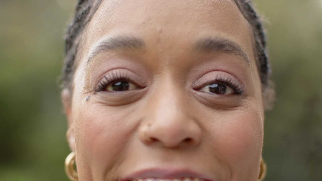 Mulher de meia-idade reagindo a um prompt gentil, arregalando os olhos, sorrindo e, em seguida, fechando os olhos em um jardim