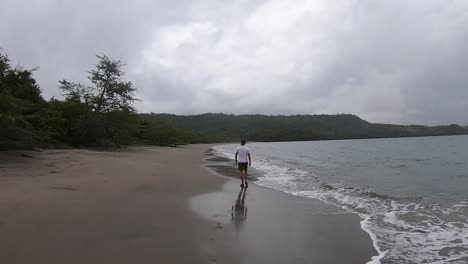 man walks on an uncrowded beach in costa rica