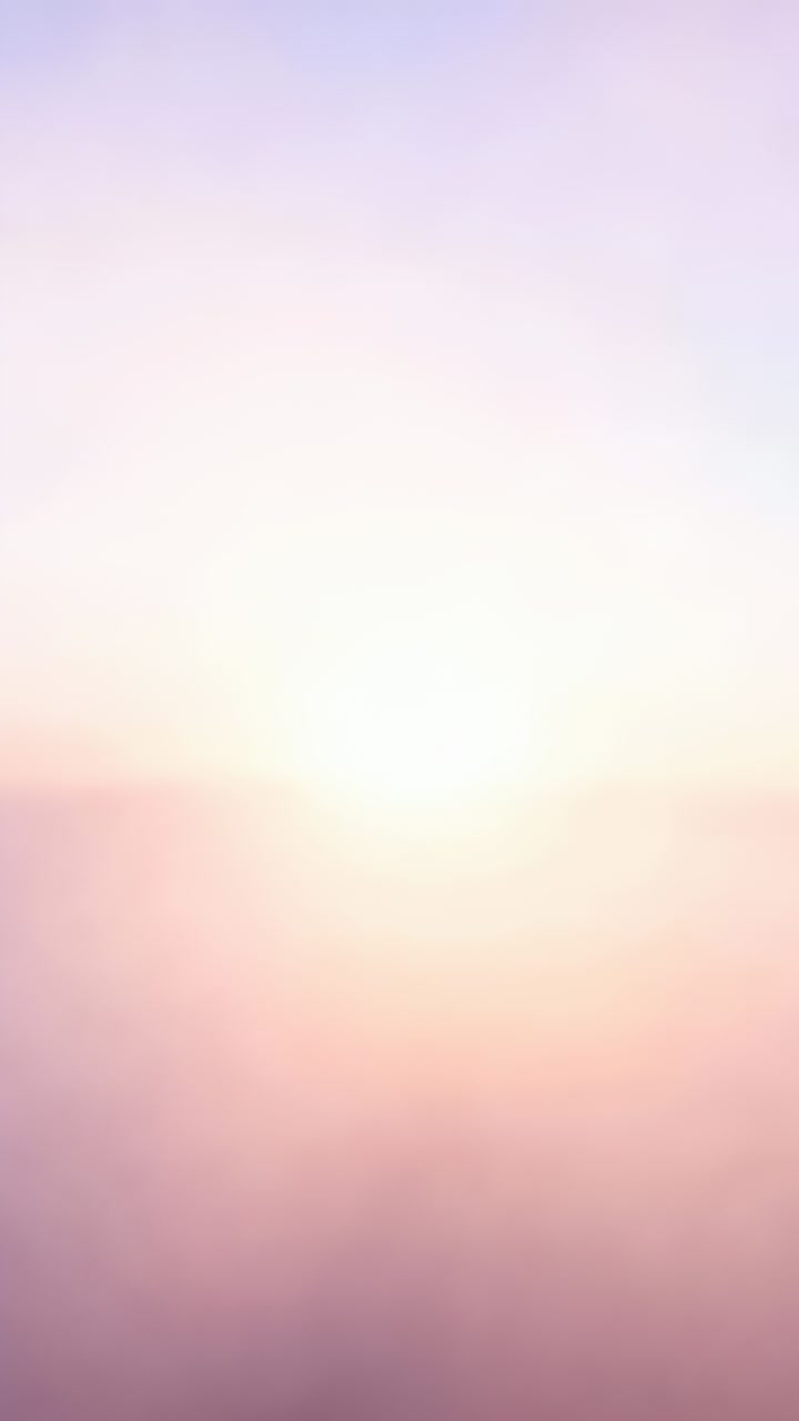 Vertical video: Recording centered bright sun shining steadily over horizon at dawn, pastel haze