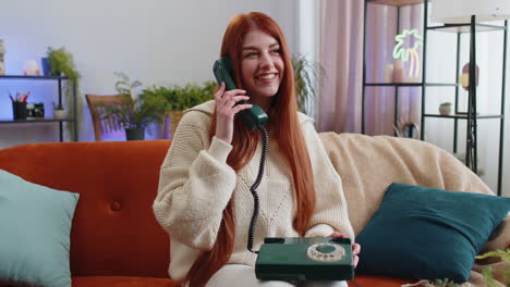 Woman-making-retro-telephone-from-90s-conversation-with-friends-sitting-call-on-sofa-at-home-in-room