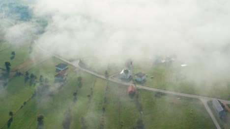 aerial shot over cloudy countryside village in serbia, mosque in local community